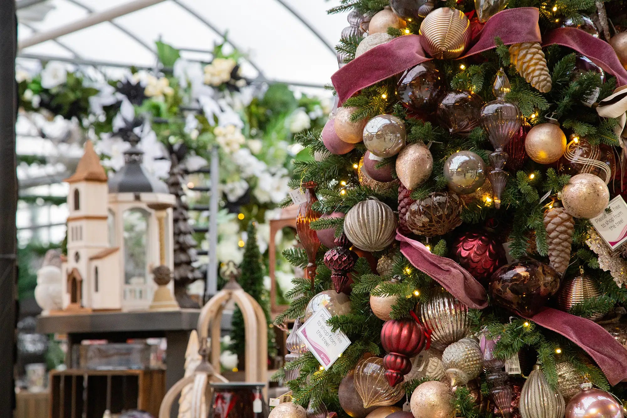 Designer-decorated Christmas tree with rose and champagne-coloured ornaments in a festive setting