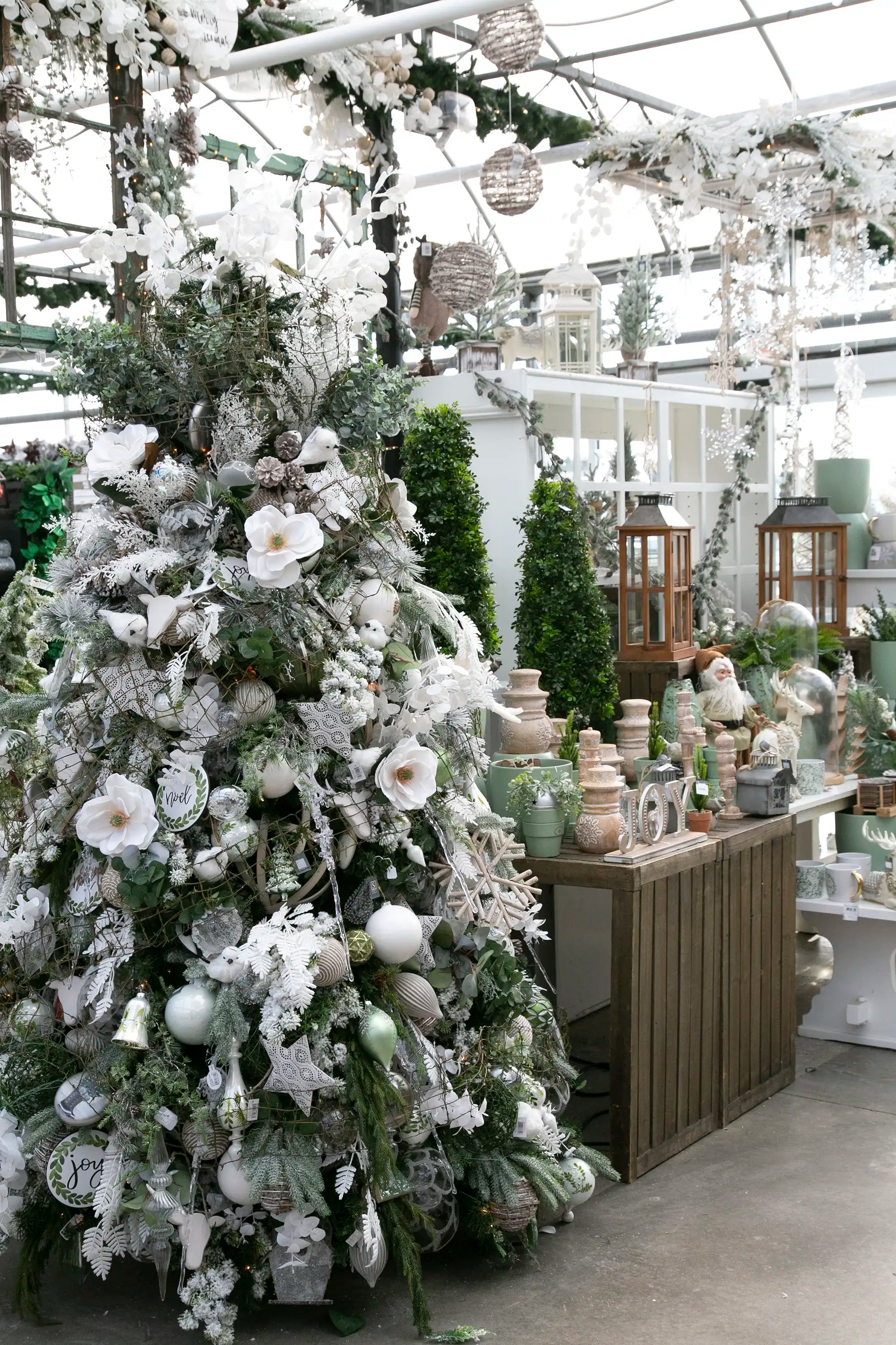 Designer-decorated Christmas tree with floral-themed ornaments in a festive setting