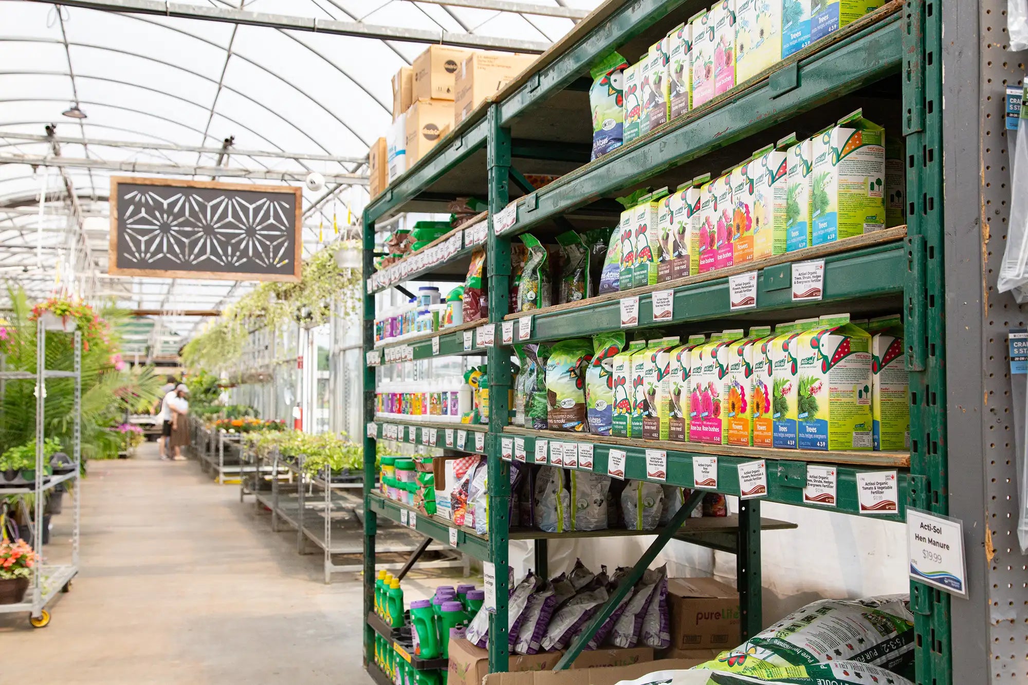 Shelves stocked with fertilizer in a greenhouse setting