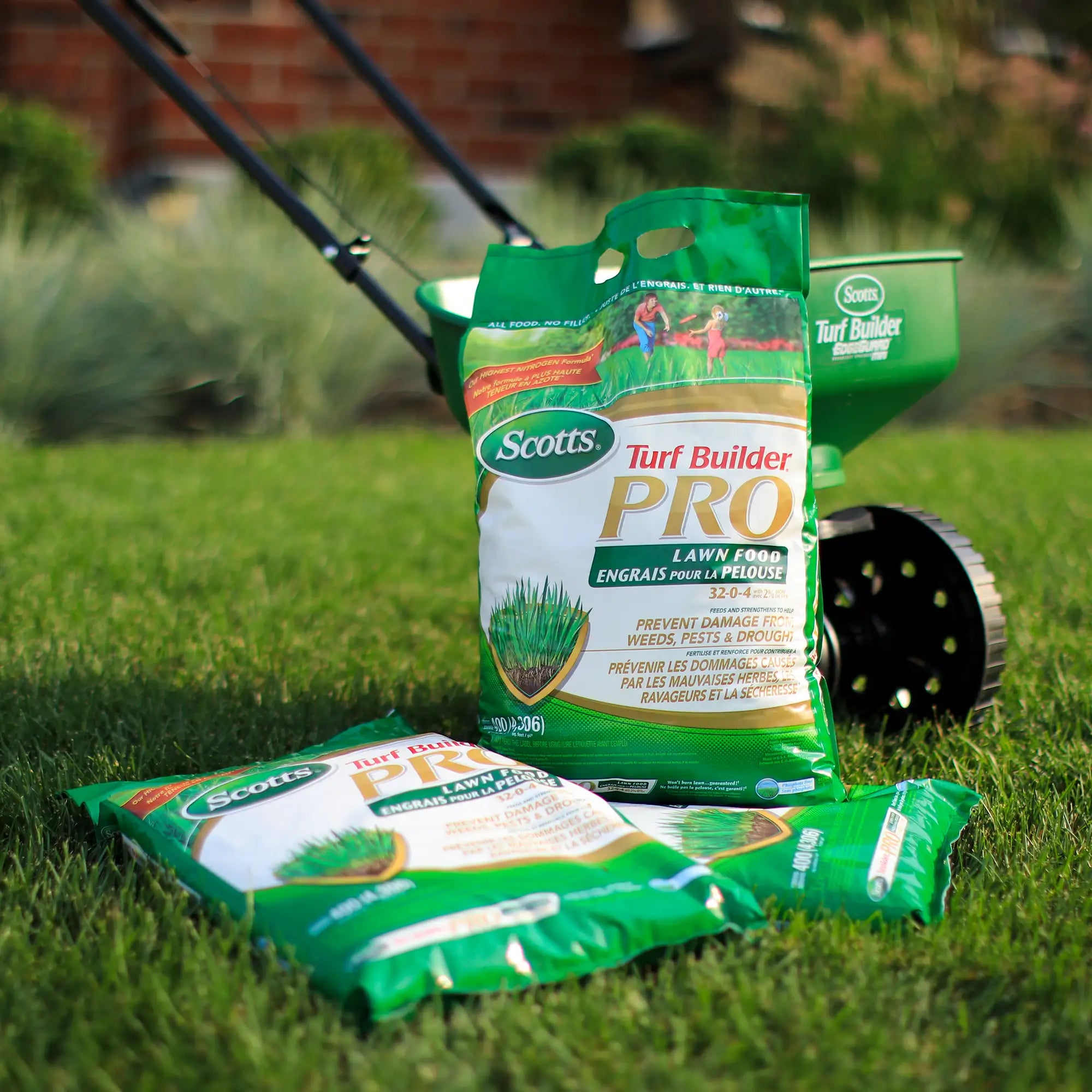 Scotts Turf Builder Pro lawn fertilizer on grass with a spreader in the background