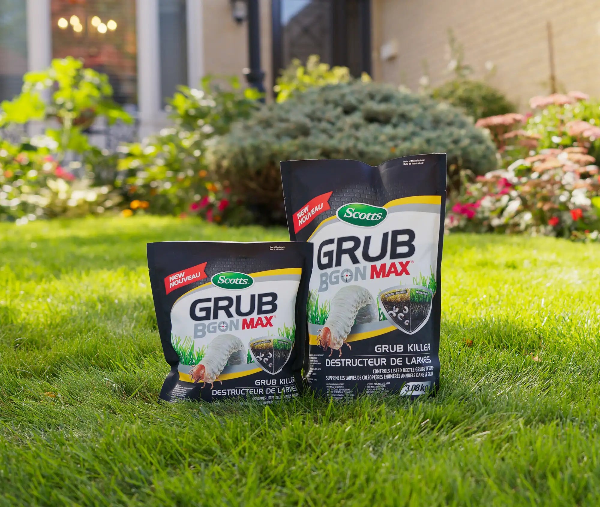 Two bags of Scotts Grub BGon Max on a grassy lawn with a garden in the background