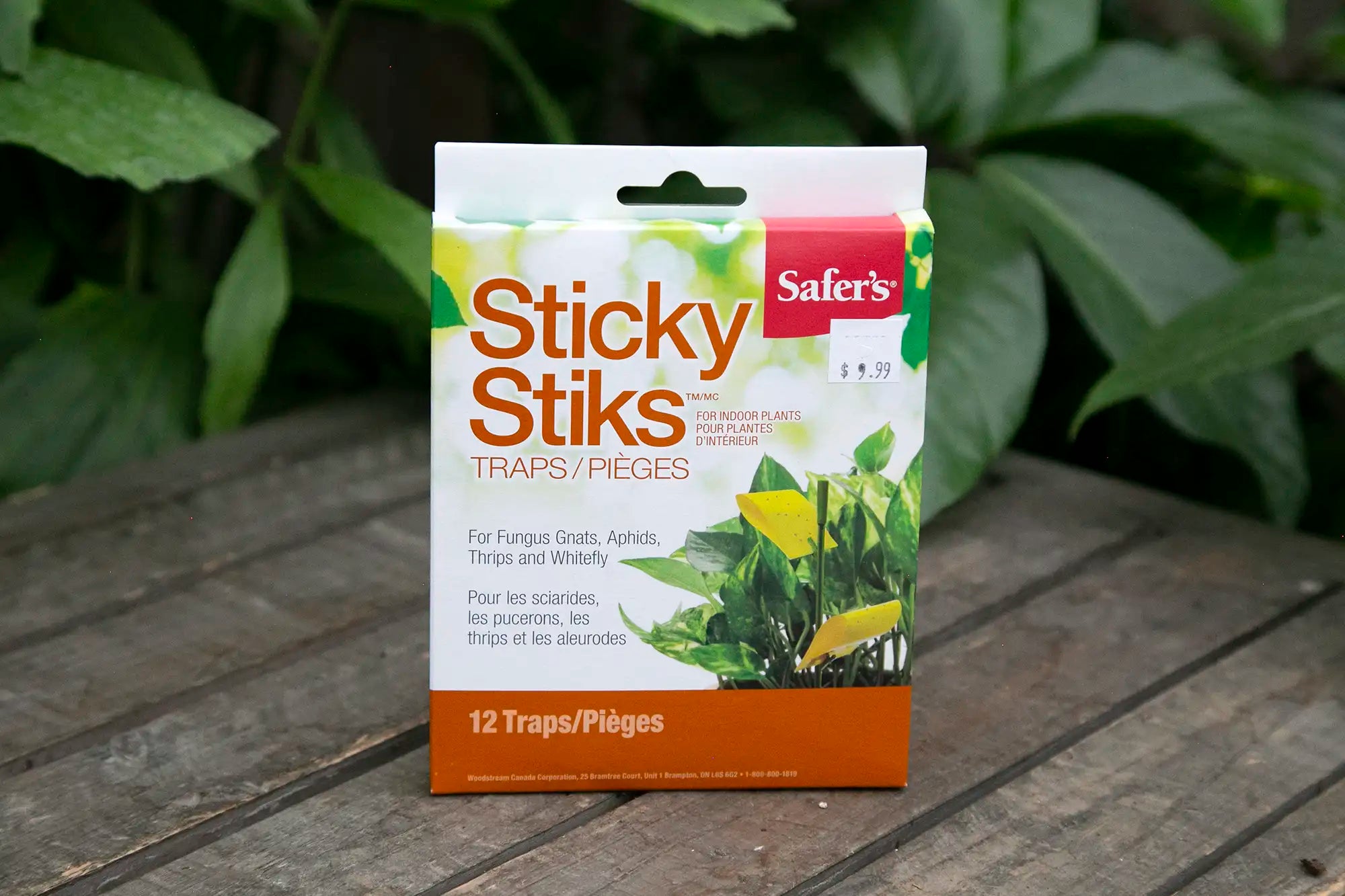 Package of Safer's Sticky Stiks traps on a wooden surface with green leaves in the background
