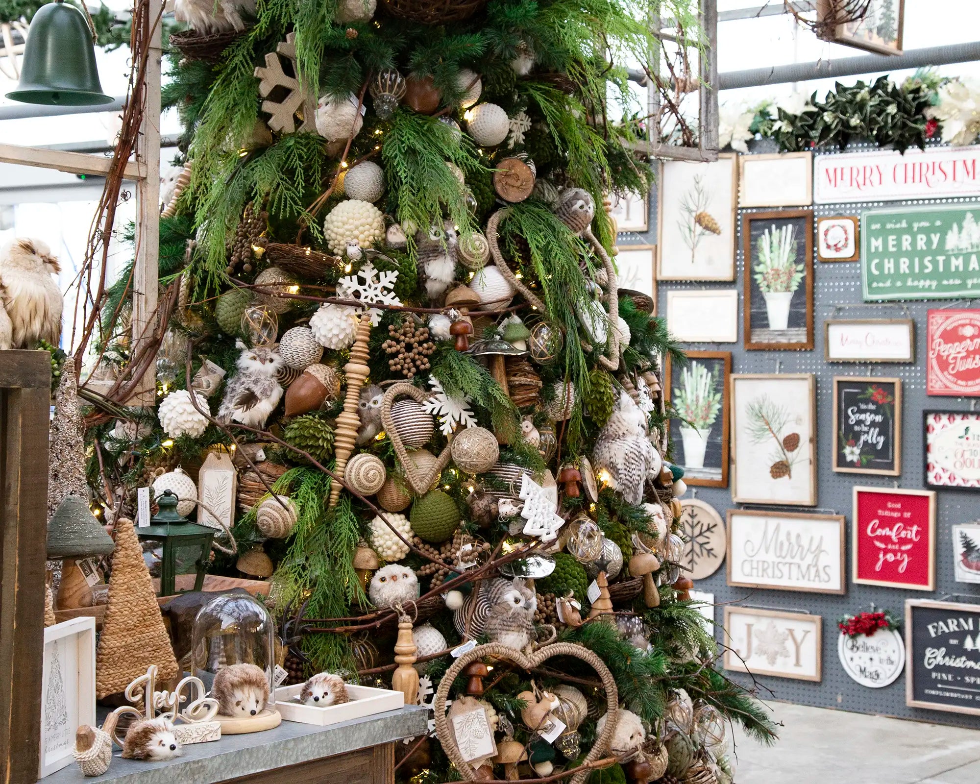 Designer-decorated Christmas tree with forest-themed ornaments in a festive setting