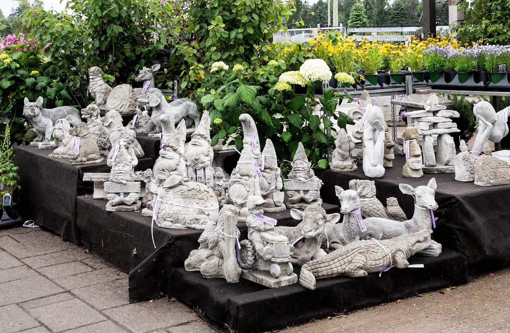 Collection of concrete garden statues on display outdoors in garden centre. 
