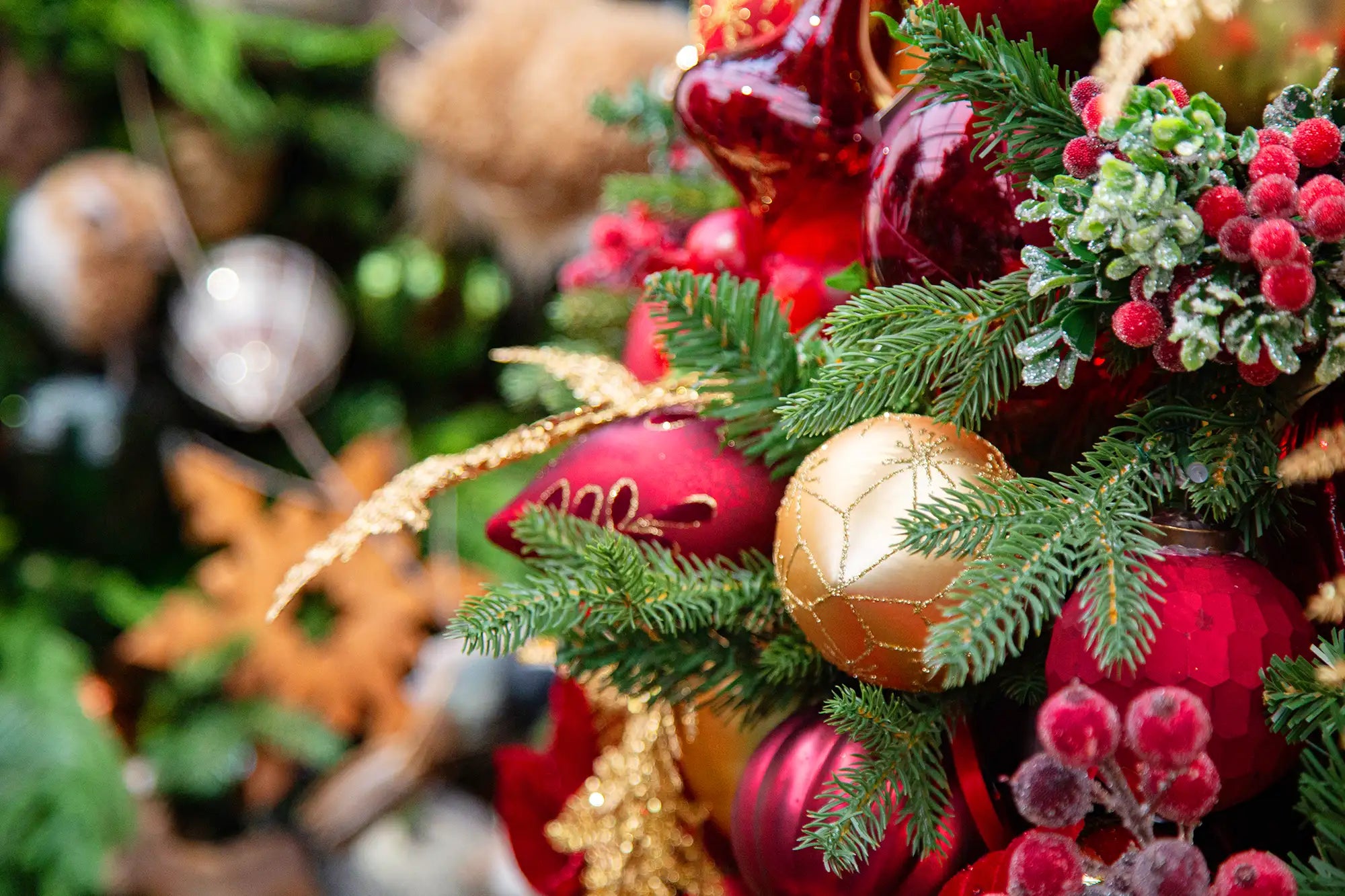 Close-up of Christmas decorations with red and gold ornaments on a blurred background